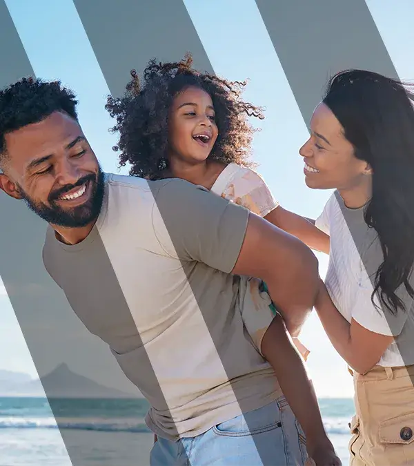 Affectionate young family of three taking a walk on the beach.