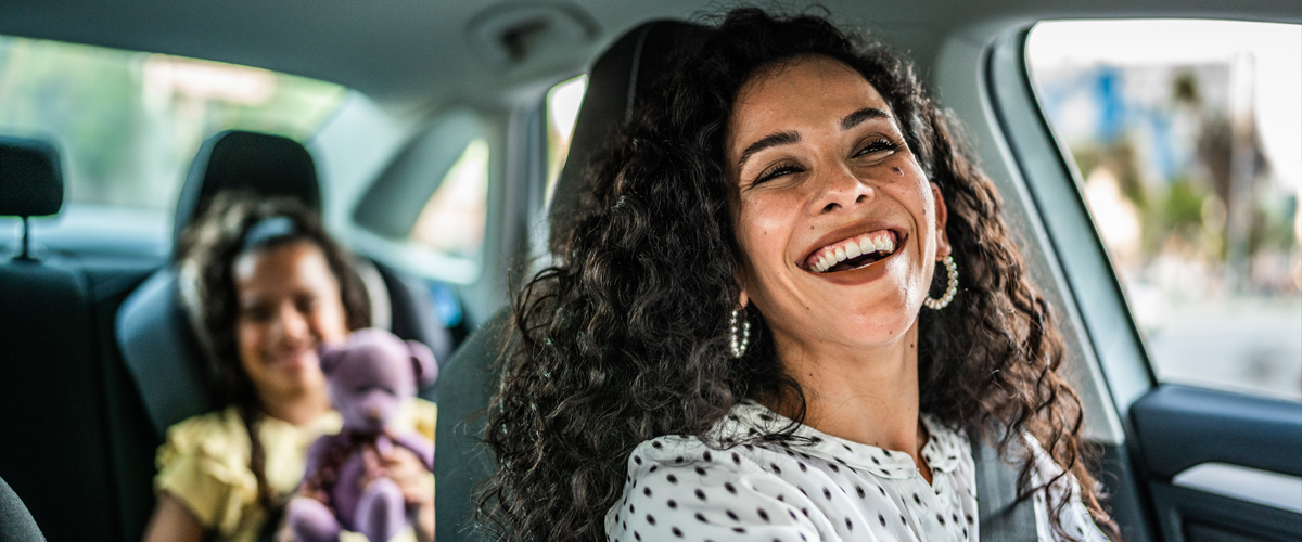 Mother and daughter talking in car while driving