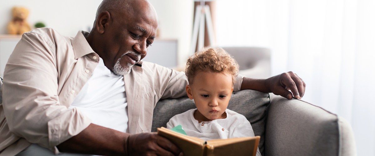 Grandfather reading a book enjoying quality time with his grandson.