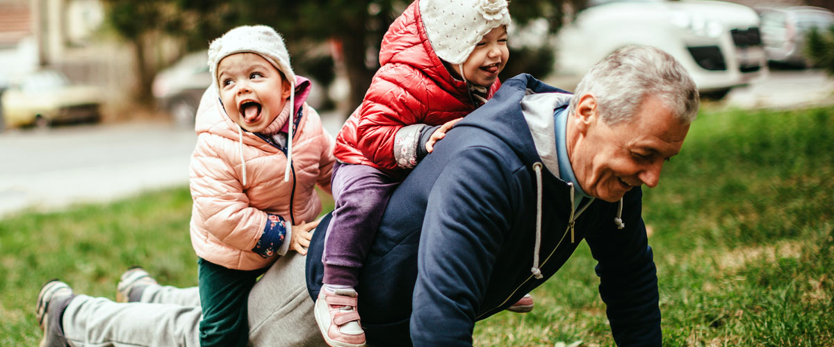 Grandfather playing with his two grandchildren.