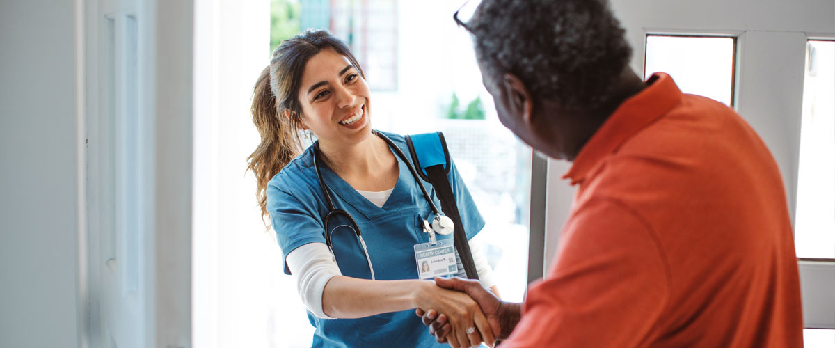 Nurse holding bag and entering a patient's home.