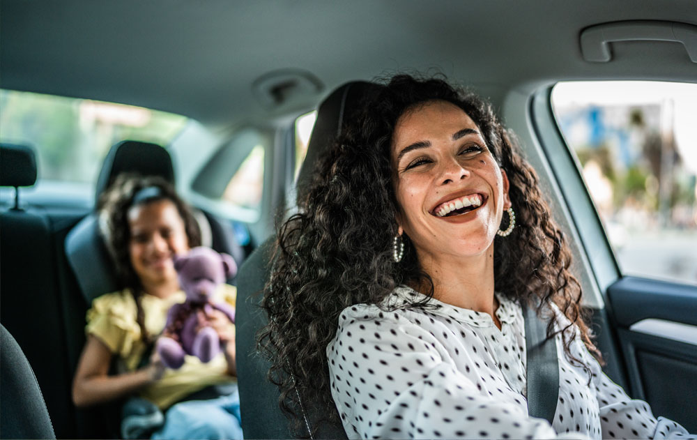 Mother and daughter talking in car while driving