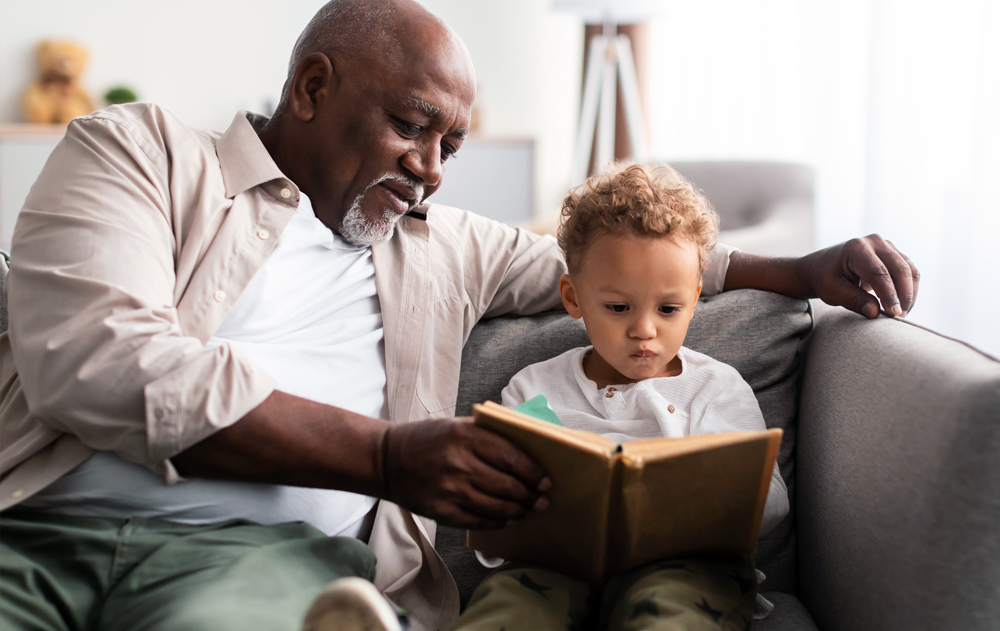 Grandfather reading a book enjoying quality time with his grandson.