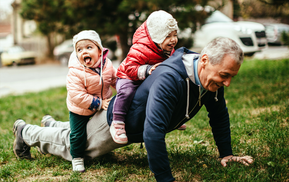 Grandfather playing with his two grandchildren.