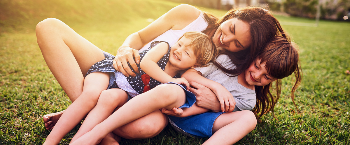 Shot of a mother bonding with her two adorable little children outdoors